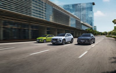 Mehrere Hyundai Neuwagen fahren nebeneinander auf einer Straße in moderner Umgebung – aktuelle Angebote im Autohaus Zondler